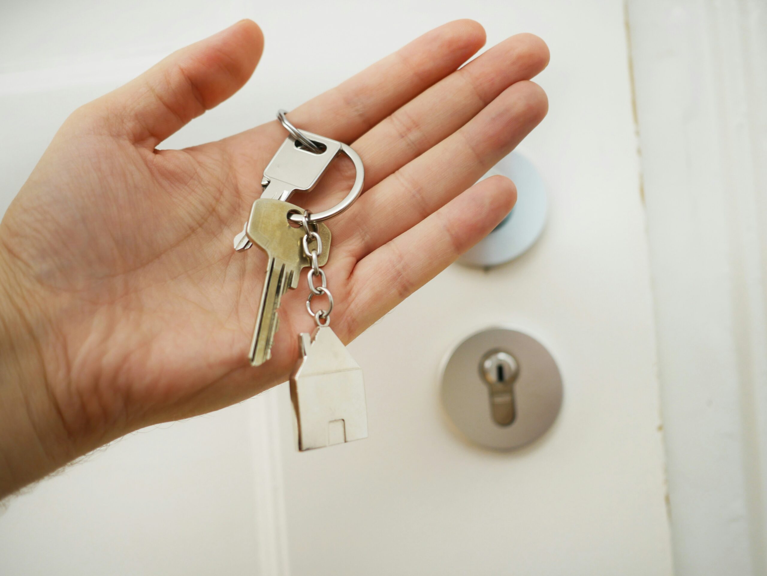 Hand holding house keys for an inherited home with a reverse mortgage